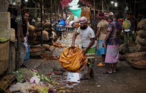 Vibrant scene of a bustling local market in Dhaka, showcasing local vendors and traditional dresses.